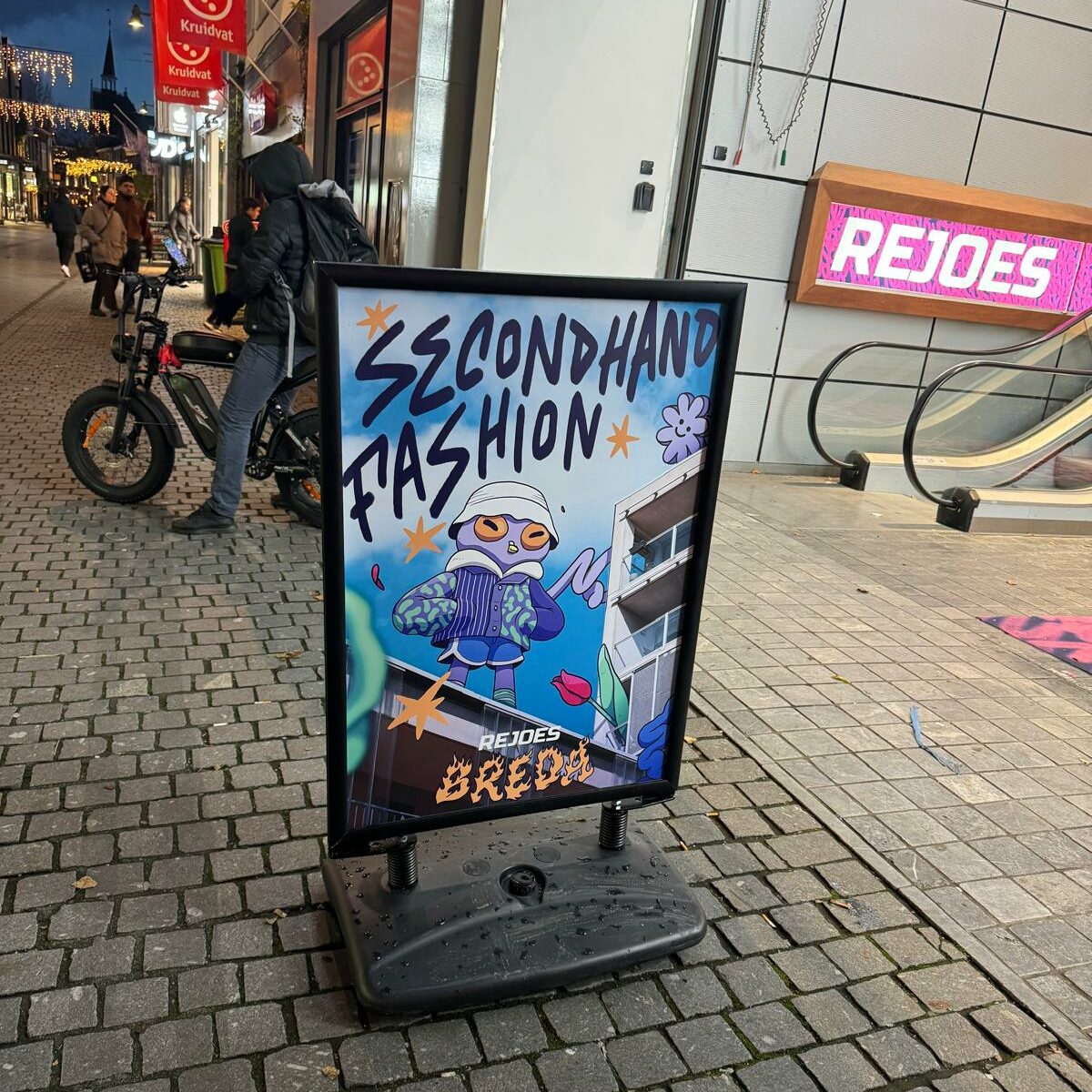 A sign that says "Second-hand fashion. Rejoes Breda". 